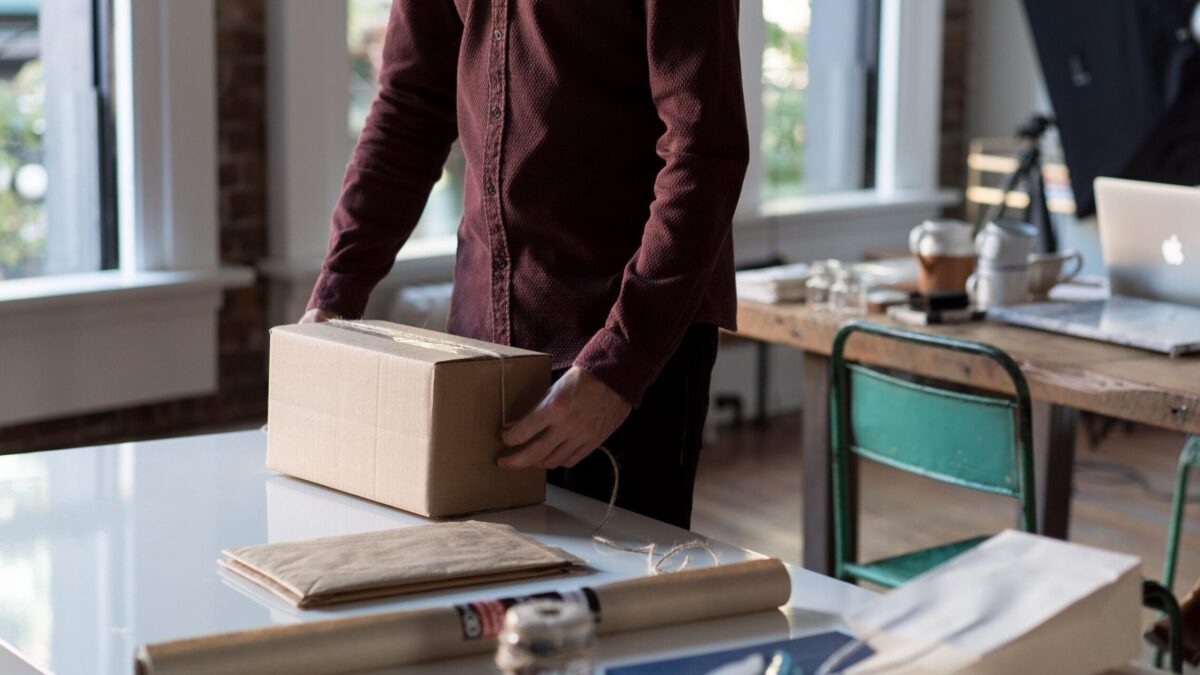 person holding cardboard box on table