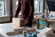 person holding cardboard box on table