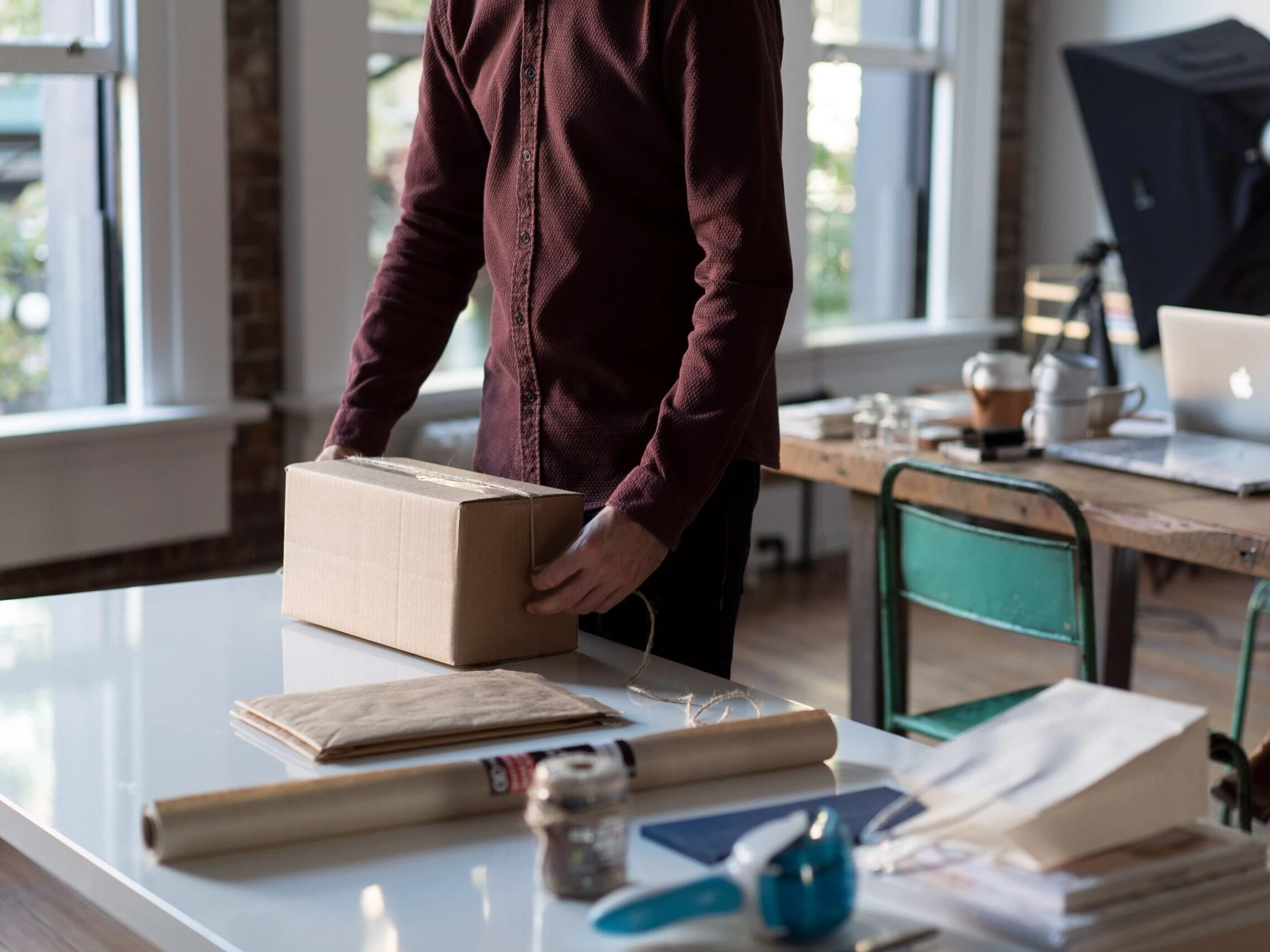 person holding cardboard box on table
