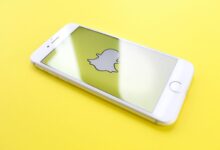 silver iPhone 6 on top of yellow wooden surface