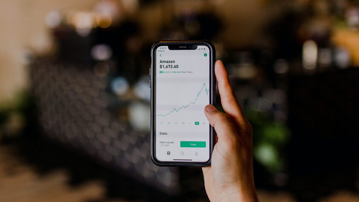 person holding black iPhone displaying stock exchange