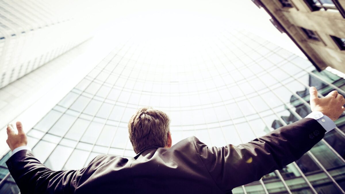 low-angle photography of man in the middle of buidligns