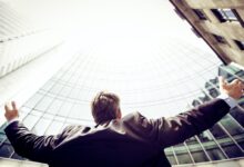 low-angle photography of man in the middle of buidligns