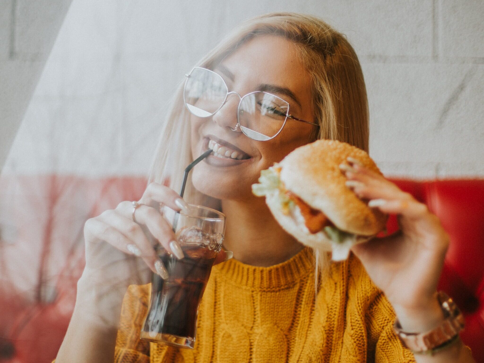 woman sitting while holding burger