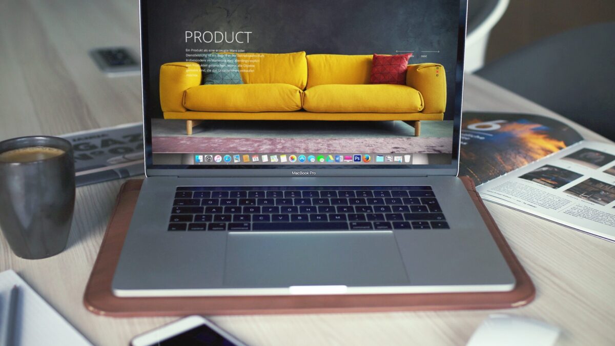 turned on MacBook Pro beside gray mug