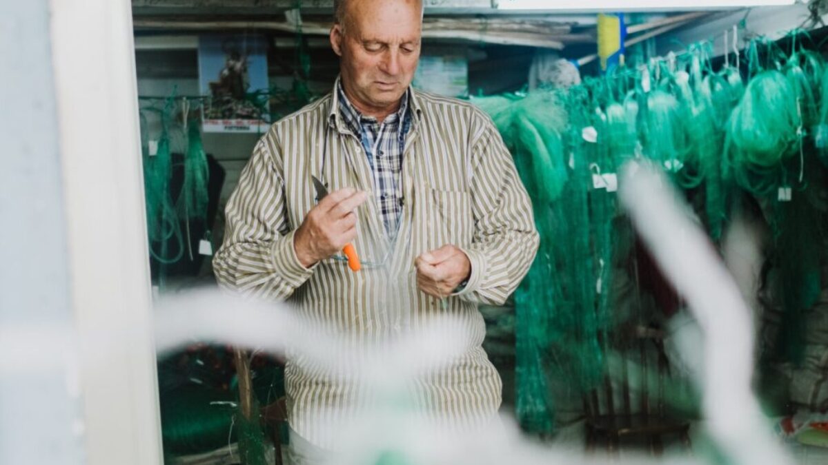 man in white and black stripe button up shirt standing near glass window