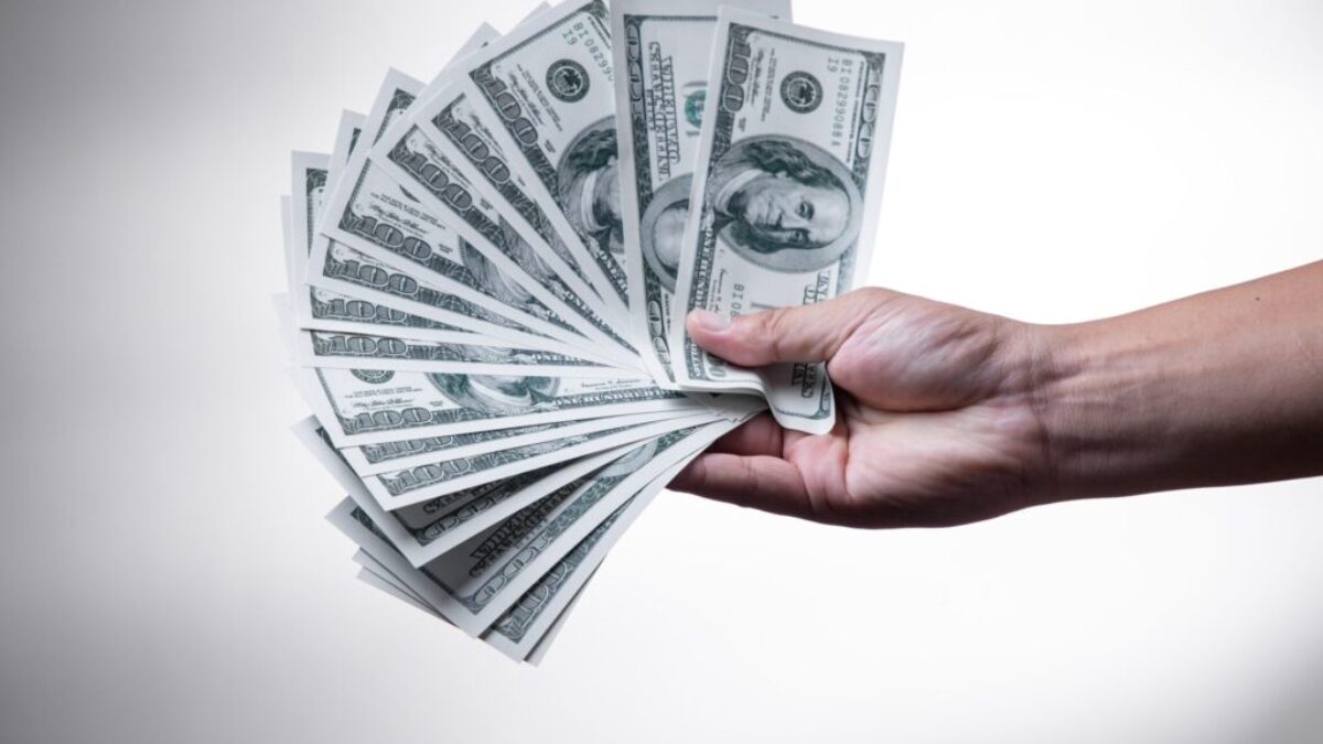 person holding 100 US Dollar banknote
