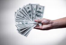 person holding 100 US Dollar banknote
