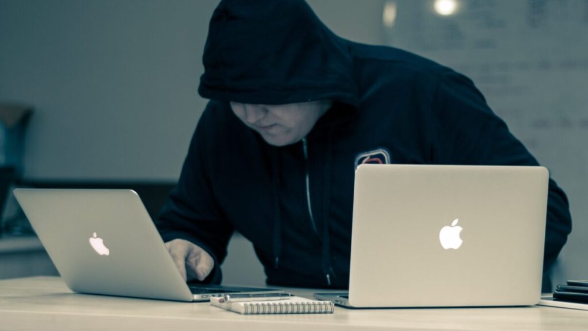 man in black hoodie using macbook