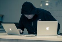 man in black hoodie using macbook