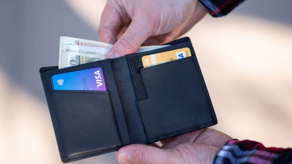 black leather bifold wallet on persons hand