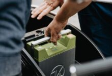 person holding black and green electronic device