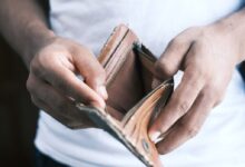 person holding brown leather bifold wallet