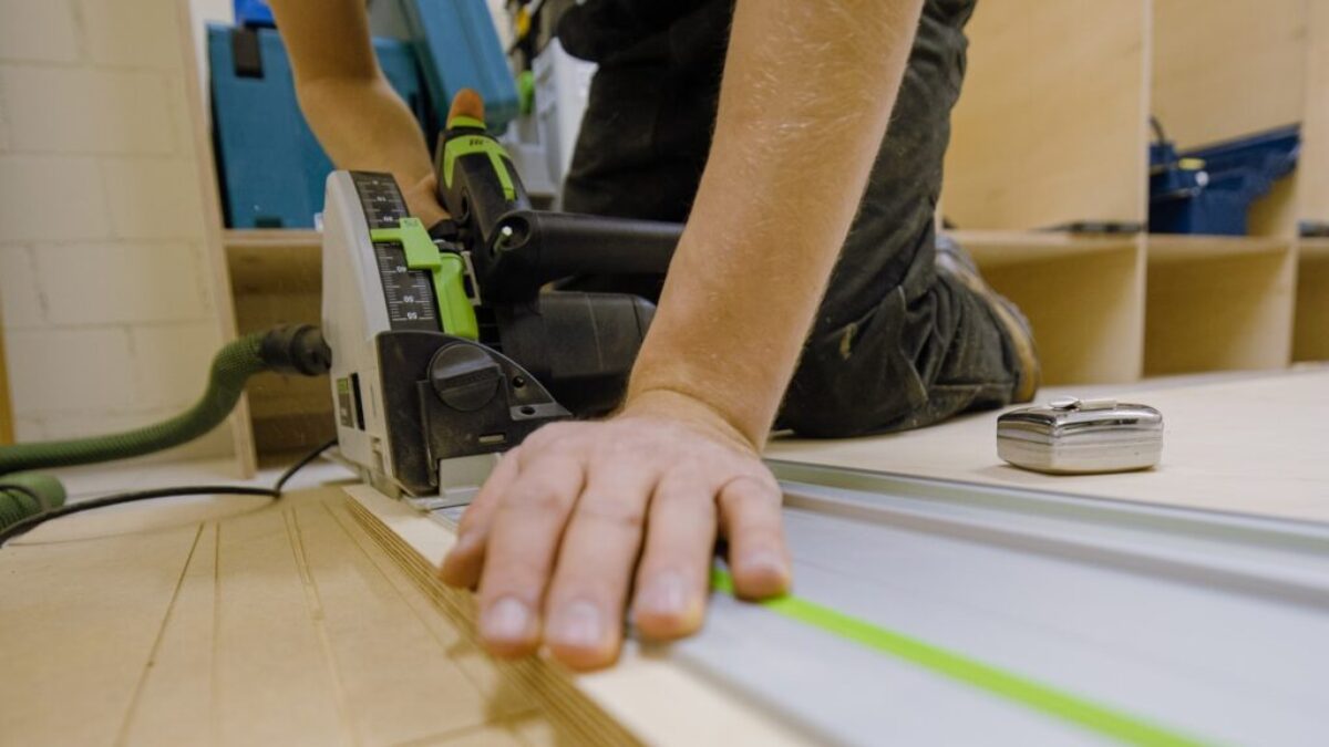 person in gray t-shirt holding green and white plastic tool