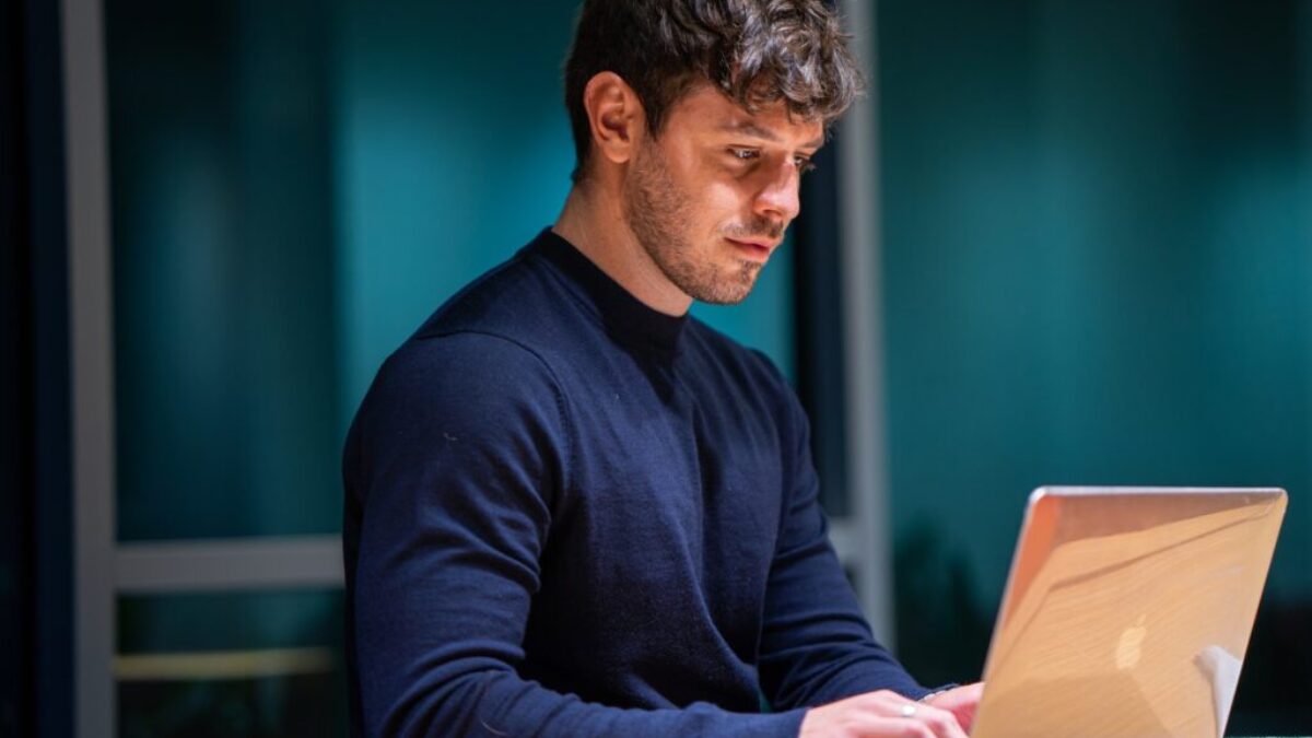 man in black long sleeve shirt using macbook