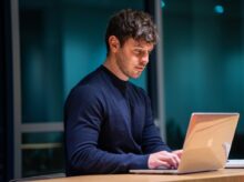 man in black long sleeve shirt using macbook