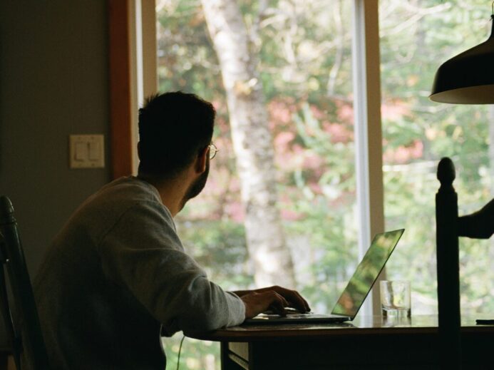 man in gray hoodie using laptop computer