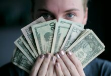 person holding fan of U.S. dollars banknote