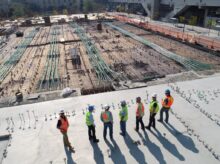 seven construction workers standing on white field