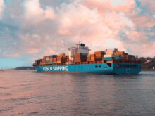 blue cargo ship on sea under cloudy sky during daytime