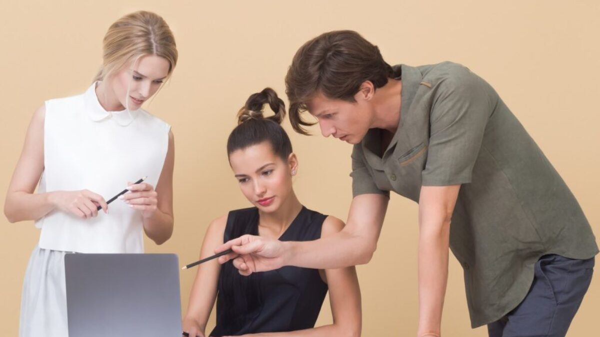 man teaching woman while pointing on gray laptop