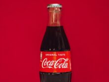 coca cola bottle on red surface