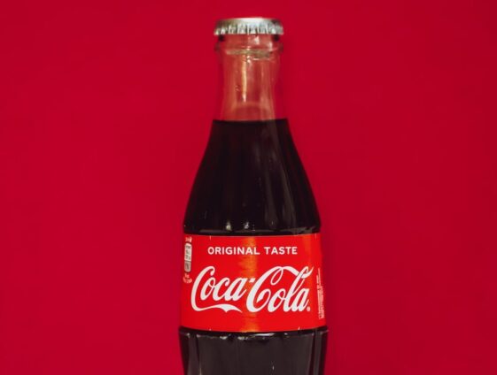 coca cola bottle on red surface