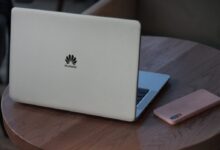 silver macbook on brown wooden table