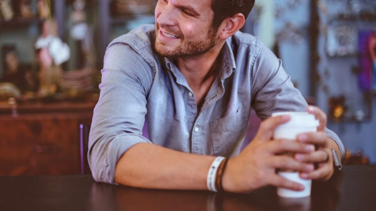 man holding cup on table