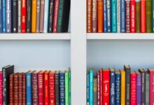 assorted-title book lot placed on white wooden shelf
