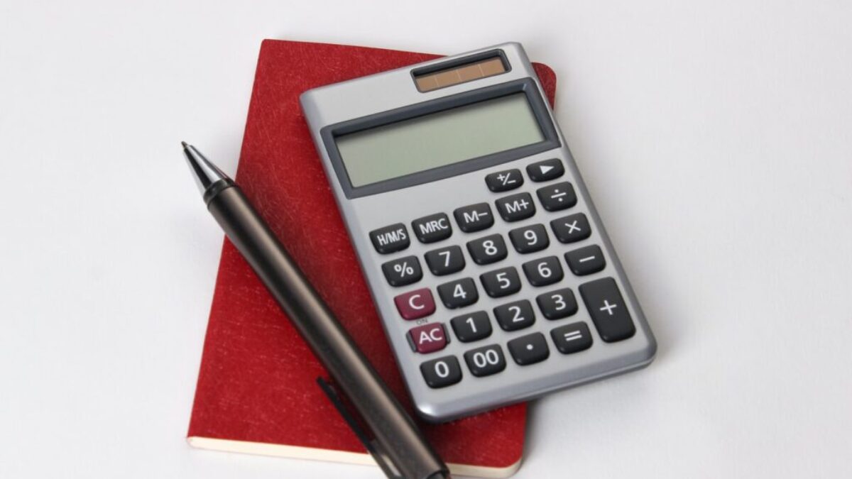 black and silver calculator beside black pen