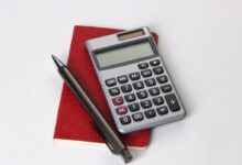 black and silver calculator beside black pen