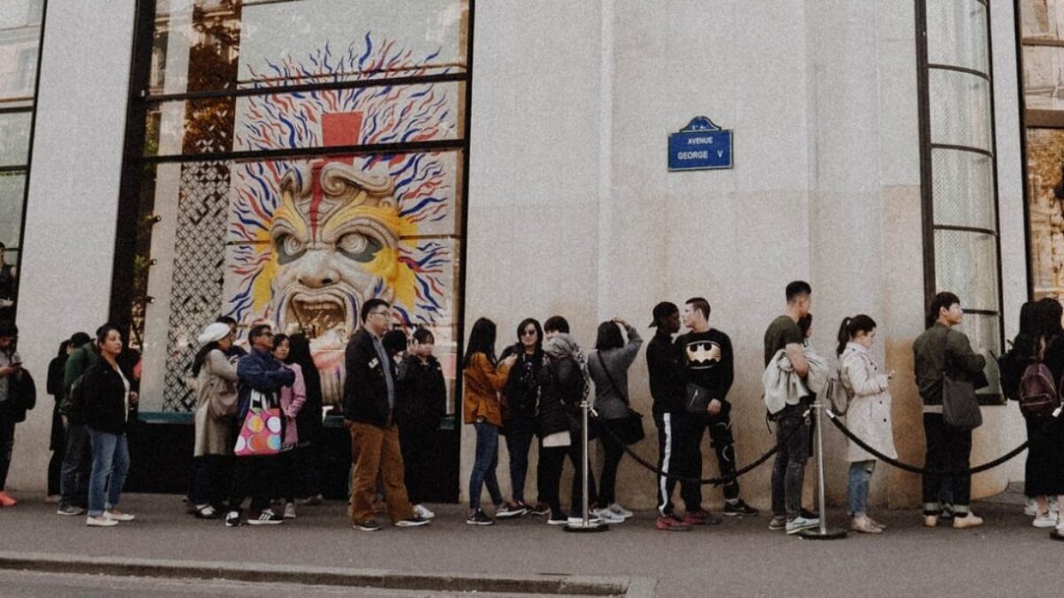 people queuing beside Louis Vuitton store