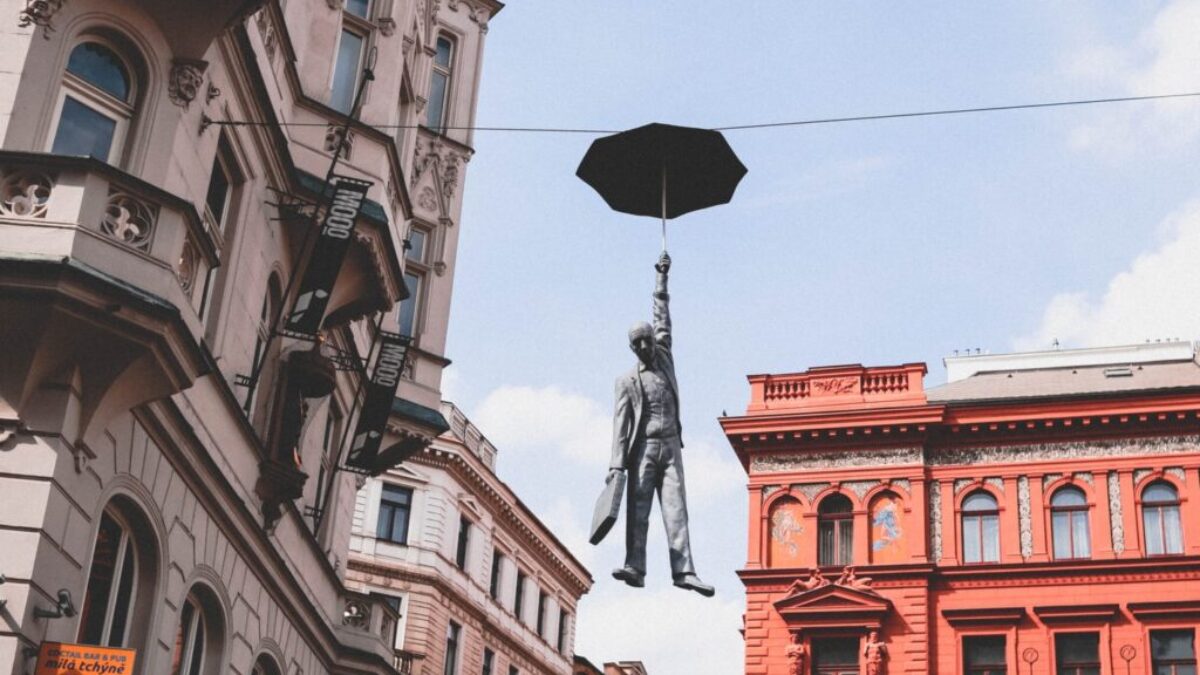 man in suit holding umbrella statue