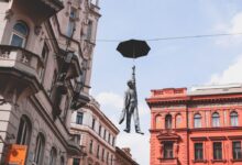 man in suit holding umbrella statue