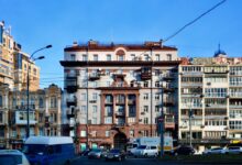 cars parked in front of beige concrete building during daytime