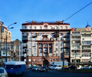 cars parked in front of beige concrete building during daytime