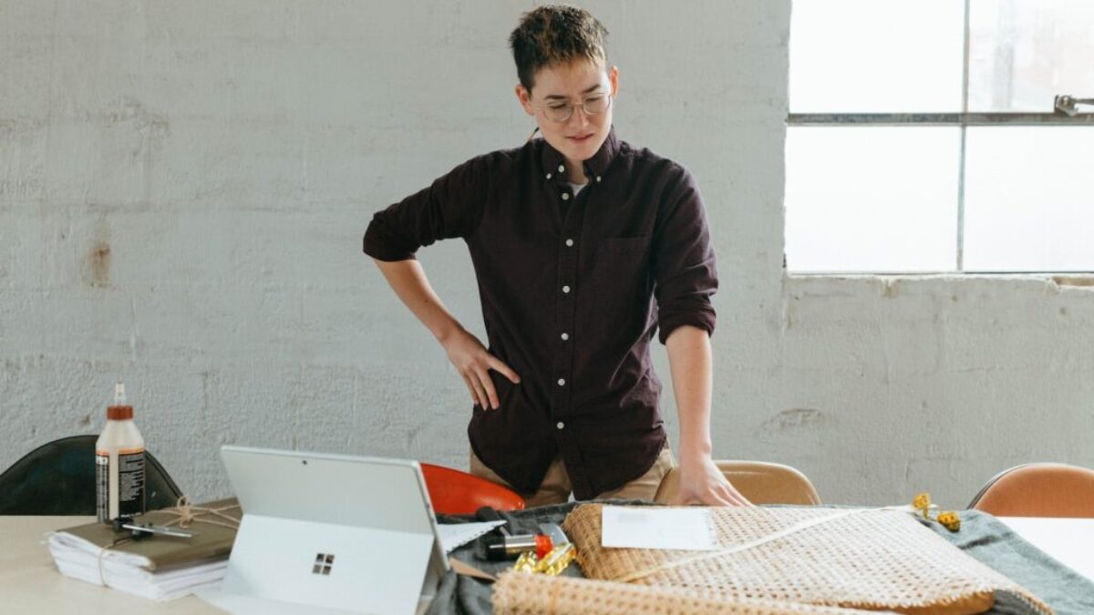 a man standing at a table with a laptop in front of him