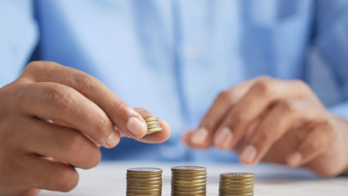 a person stacking coins on top of a table