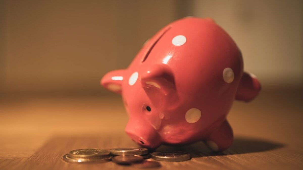 pink pig coin bank on brown wooden table