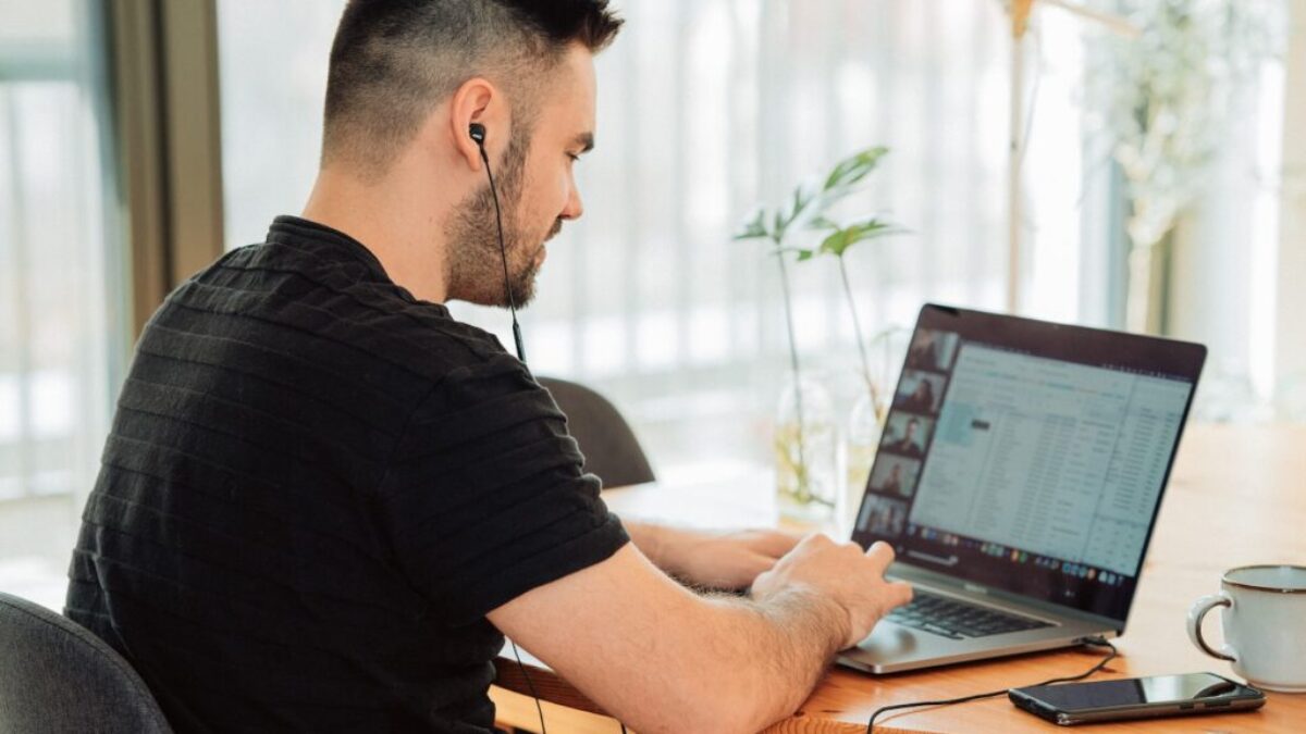 man in black t-shirt using macbook pro