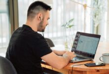 man in black t-shirt using macbook pro