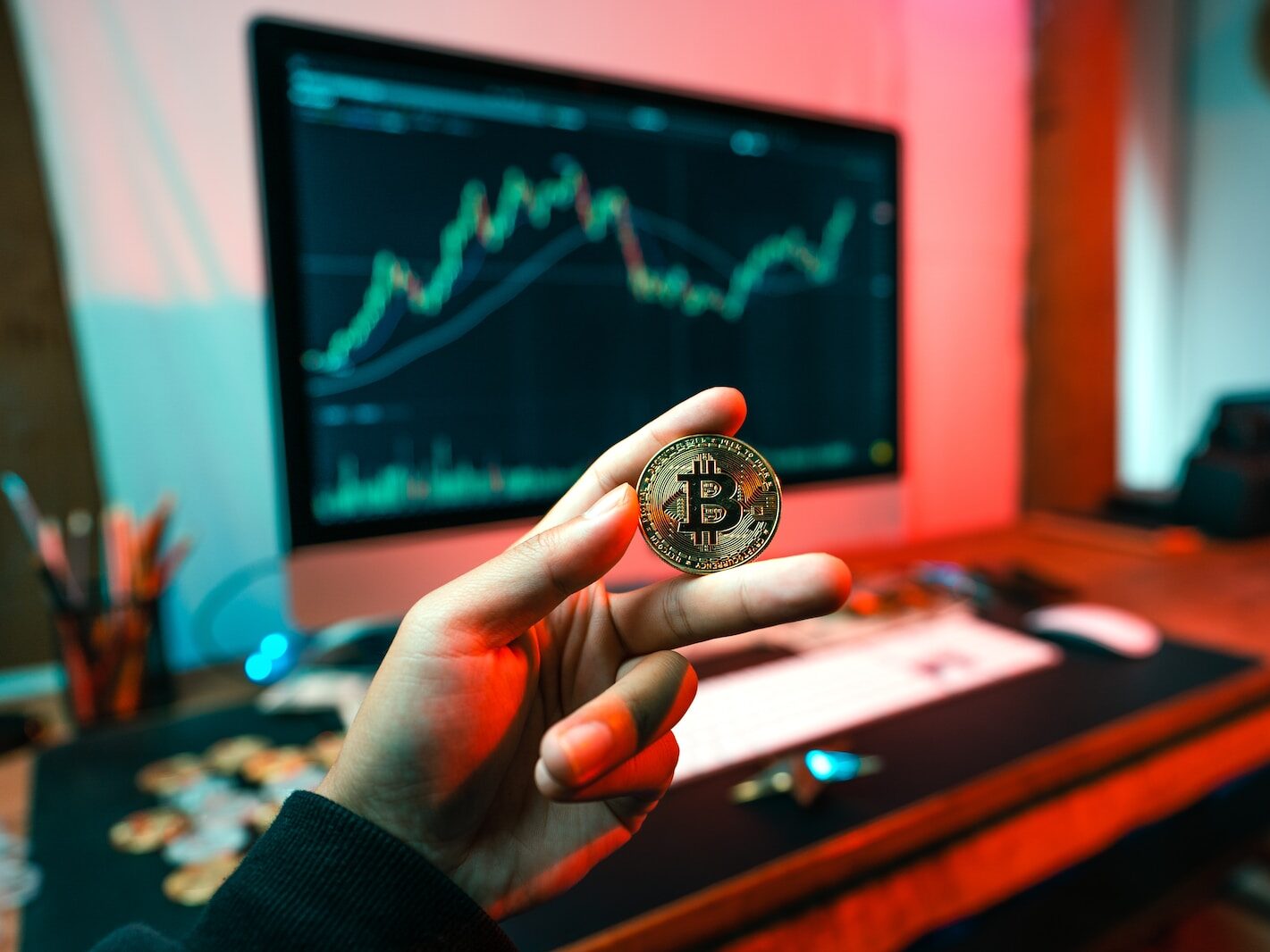 a person holding a coin in front of a computer