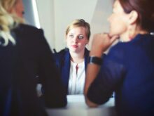 three women sitting beside table