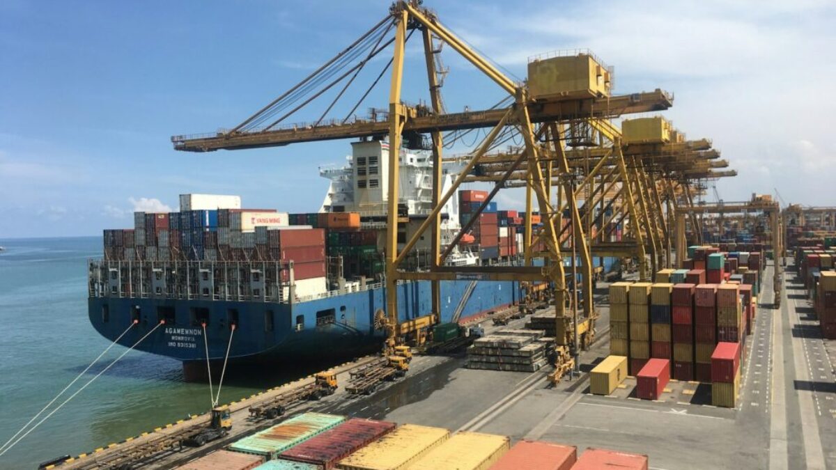 ship on dock near shipping containers