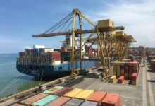 ship on dock near shipping containers