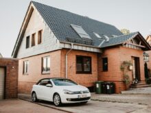 white Volkswagen Jetta parked beside house