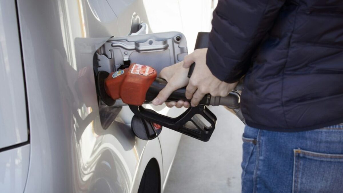 a man pumping gas into his car at a gas station