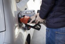 a man pumping gas into his car at a gas station