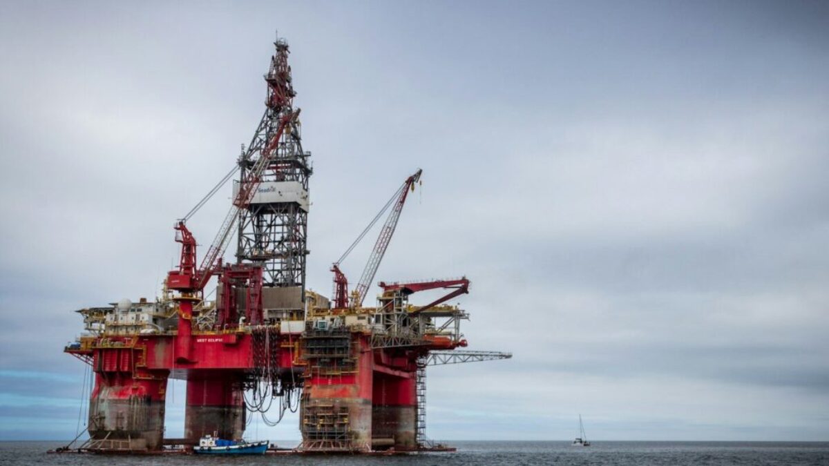 red and grey oil platform in sea